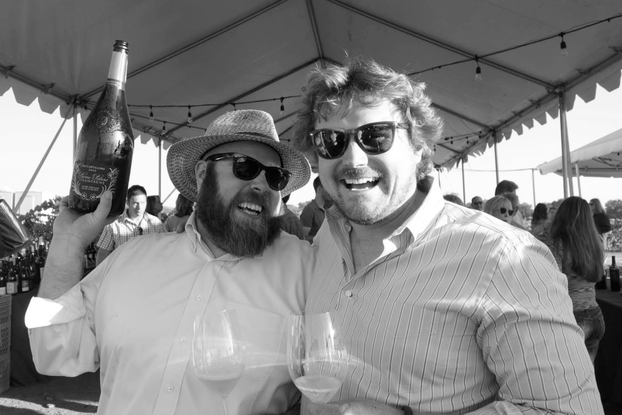 Chris Cottrell and Morgan Twain-Peterson holding a champagne bottle at a Bedrock harvest party